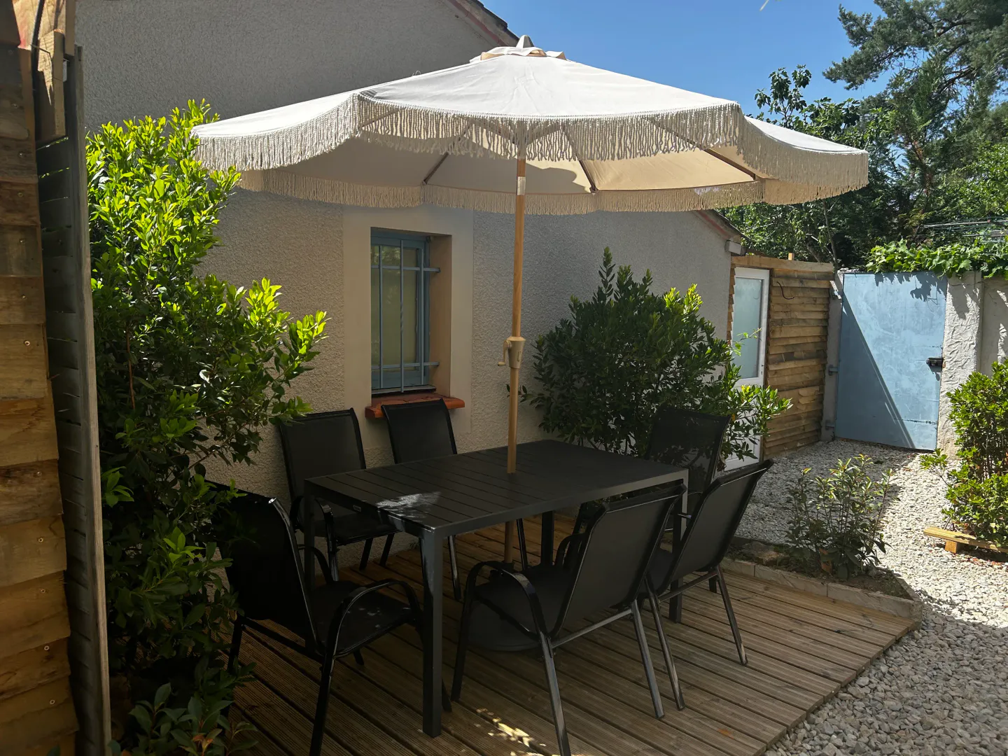 La terrasse de la maison avec sa table et son parasol
